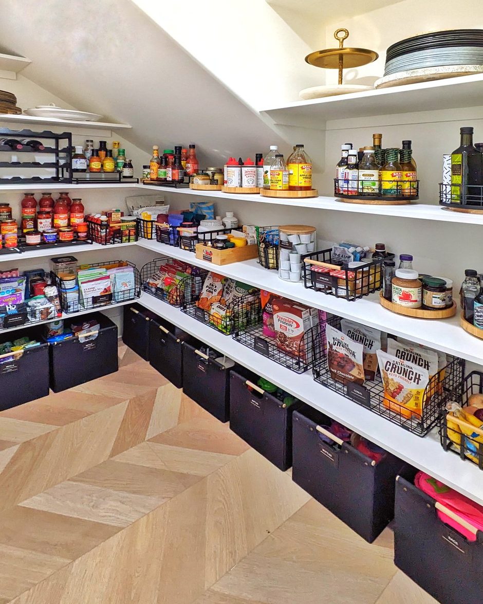 The same walk-in pantry after: turntables, wire baskets, and labeled black bins on every shelf