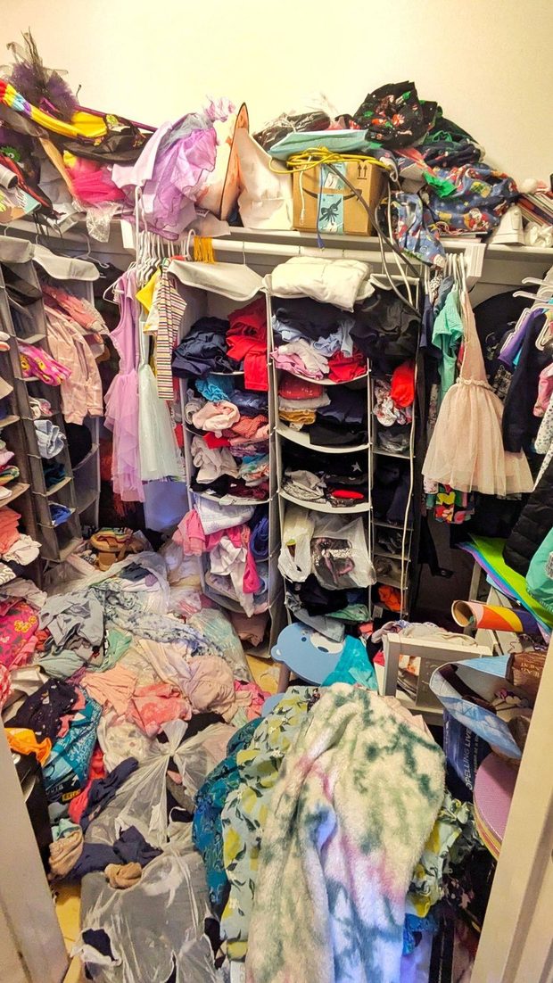 The closet before: clothes piled knee-deep across the floor and spilling off every shelf