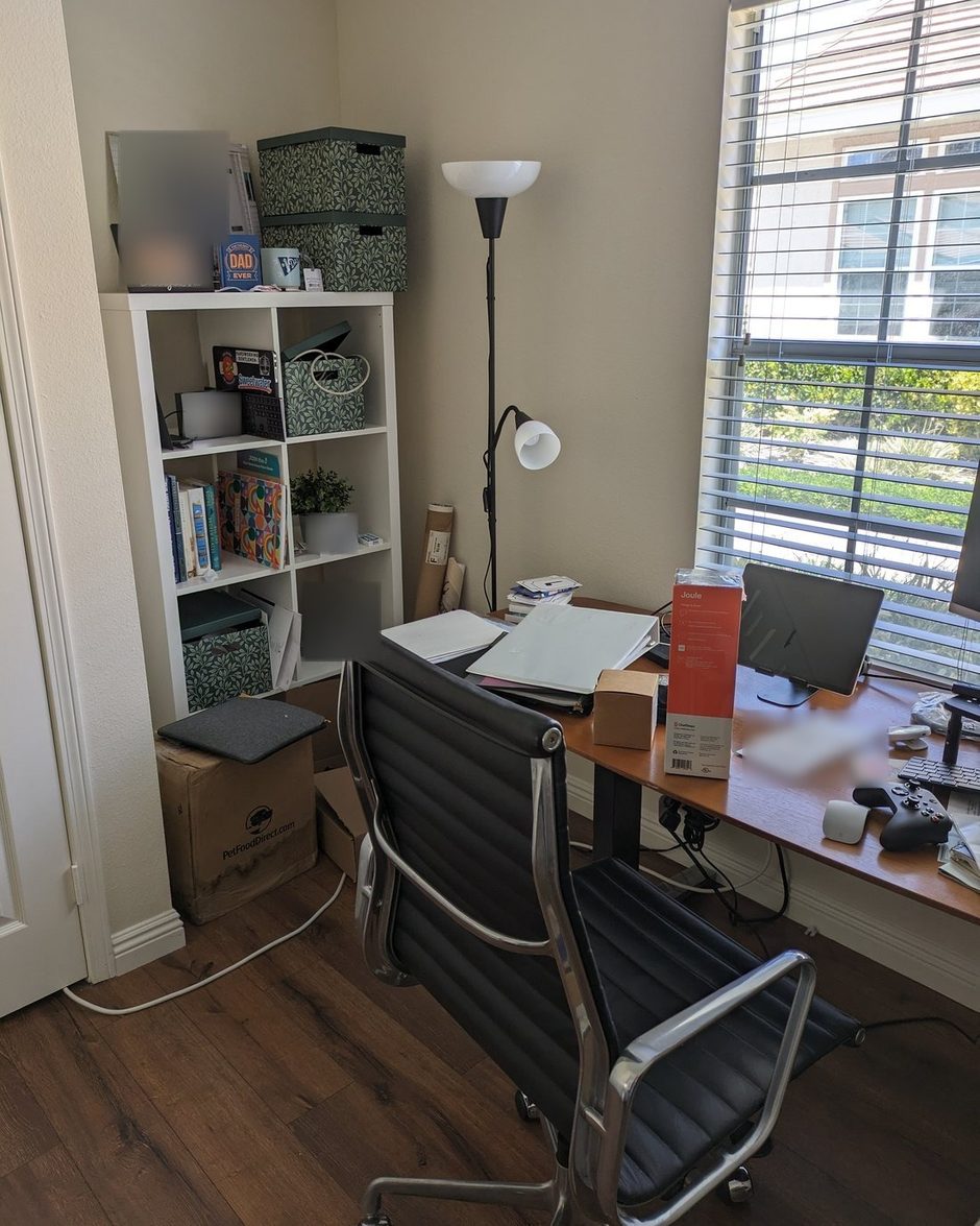 The home office before: piled papers, boxes on the floor, crowded shelf