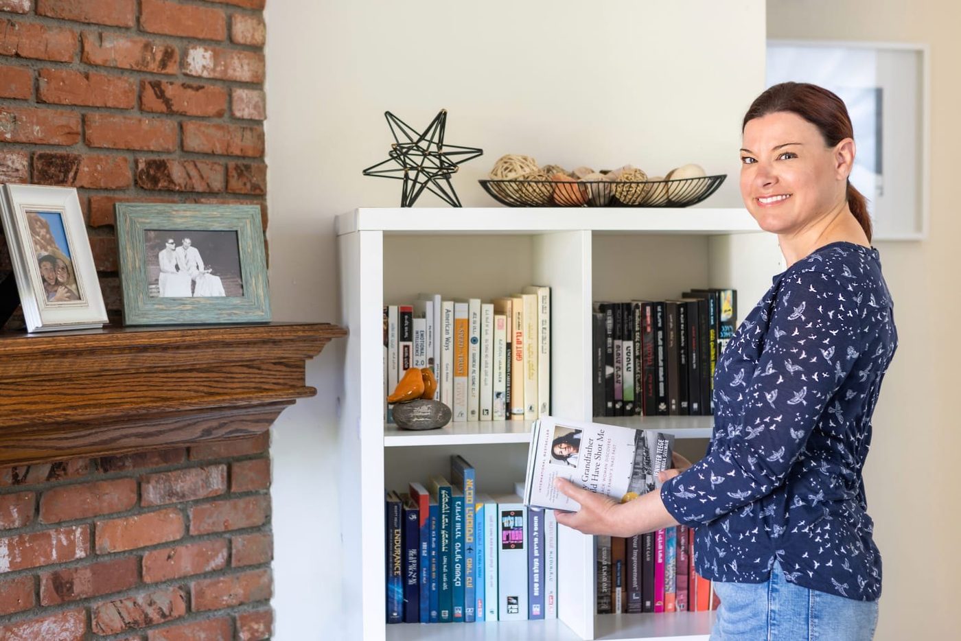 Tammy arranging books on a client's shelves